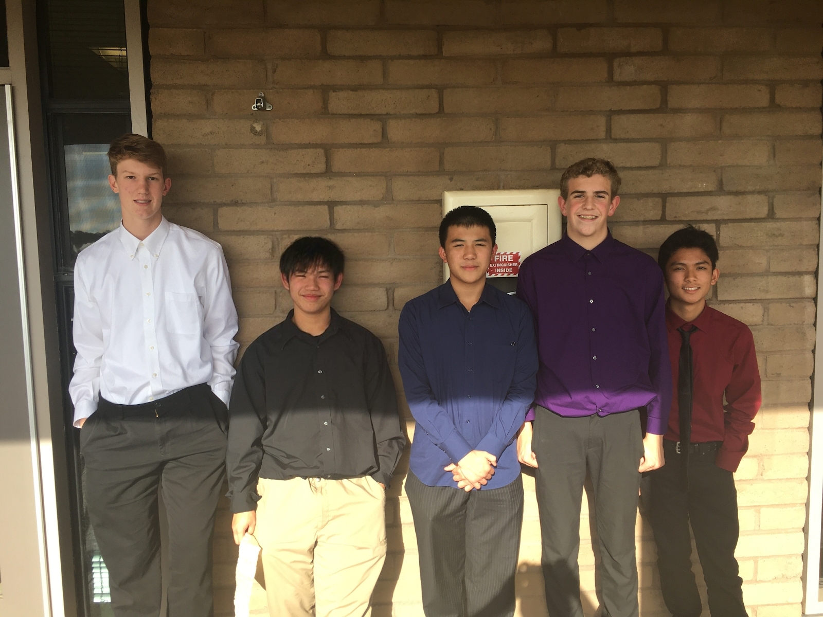 5 Kids standing next to a brick wall